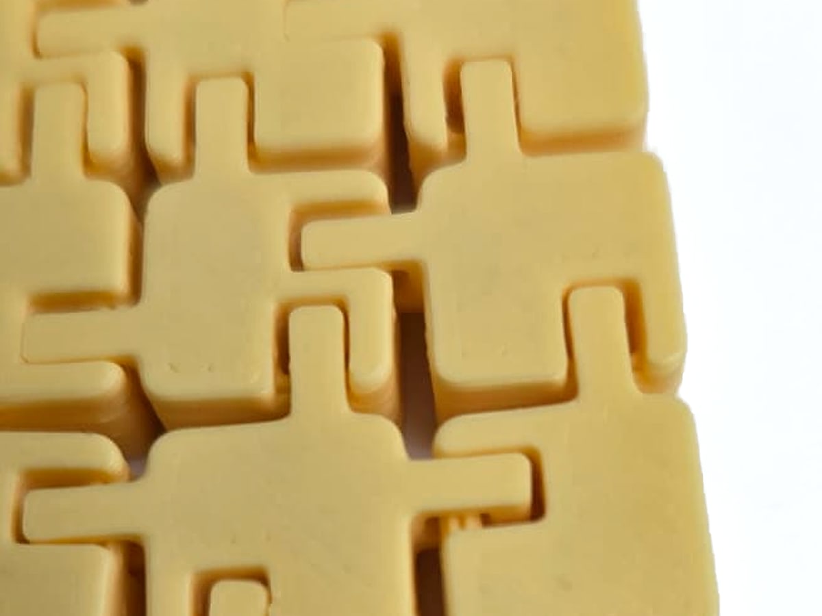Yellow 3D-printed interlocking tiles fitted together at a corner
