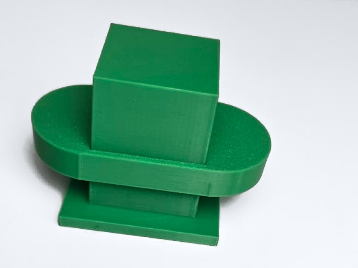 Green 3D-printed square stud on an oval plate and a square base