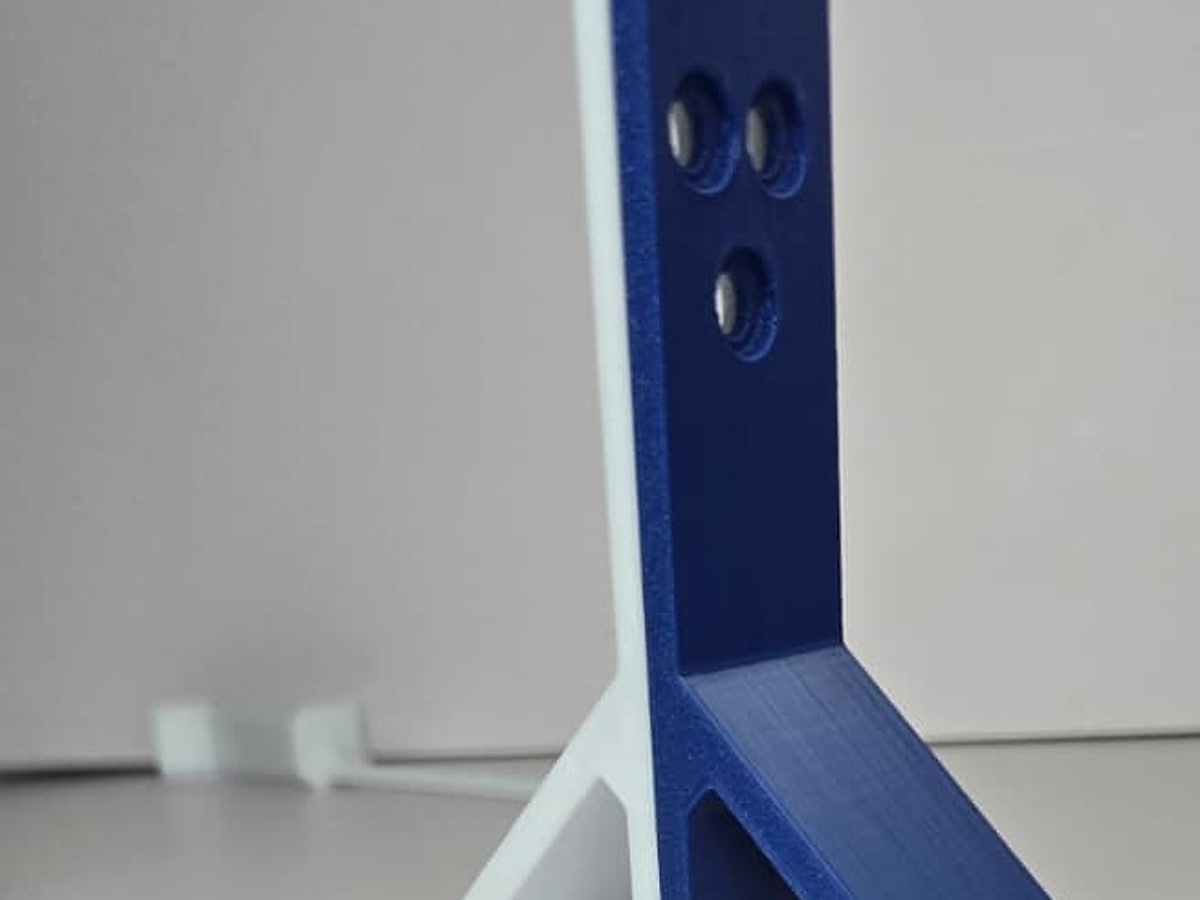 Two-color 3D-printed wall bracket with three countersunk holes and triangular ribs